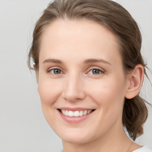 Joyful white young-adult female with medium  brown hair and blue eyes