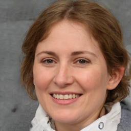 Joyful white adult female with medium  brown hair and blue eyes