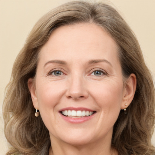 Joyful white adult female with long  brown hair and grey eyes