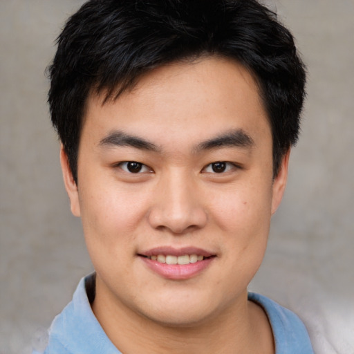 Joyful asian young-adult male with short  brown hair and brown eyes