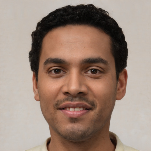 Joyful latino young-adult male with short  black hair and brown eyes