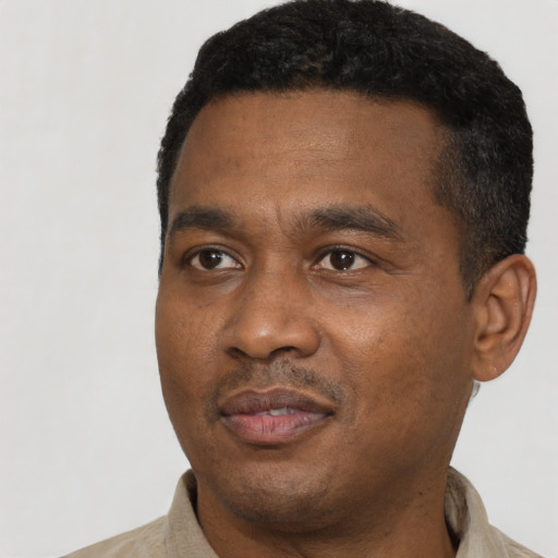 Joyful black young-adult male with short  black hair and brown eyes