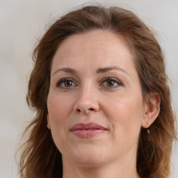 Joyful white adult female with long  brown hair and brown eyes