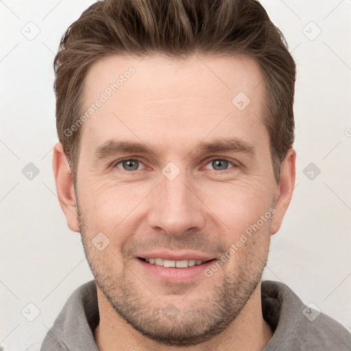 Joyful white young-adult male with short  brown hair and grey eyes