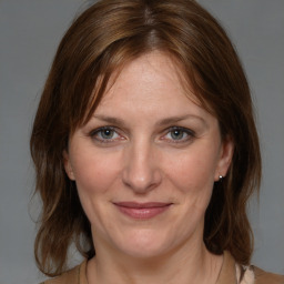 Joyful white adult female with medium  brown hair and grey eyes