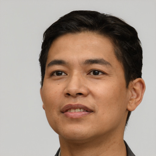 Joyful latino young-adult male with short  black hair and brown eyes