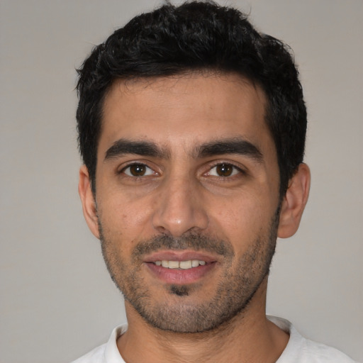 Joyful white young-adult male with short  black hair and brown eyes