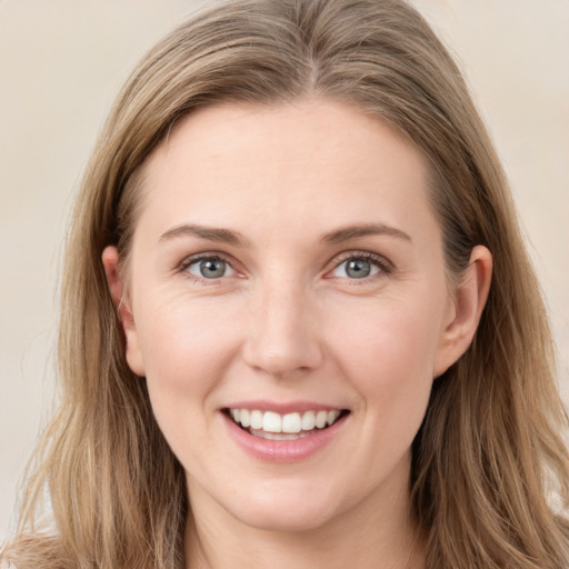 Joyful white young-adult female with long  brown hair and blue eyes