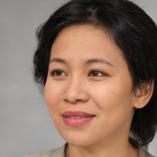 Joyful asian adult female with medium  brown hair and brown eyes