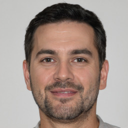 Joyful white adult male with short  brown hair and brown eyes