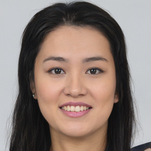 Joyful asian young-adult female with long  brown hair and brown eyes