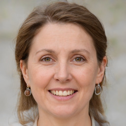 Joyful white adult female with medium  brown hair and blue eyes