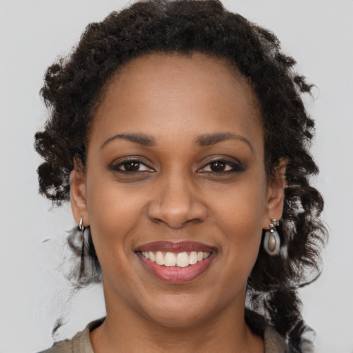 Joyful black young-adult female with medium  brown hair and brown eyes
