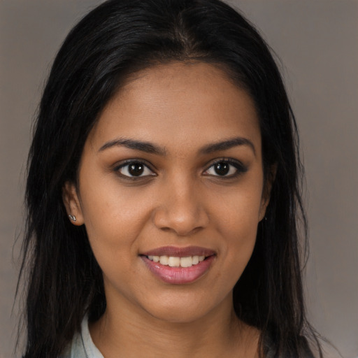 Joyful black young-adult female with long  brown hair and brown eyes