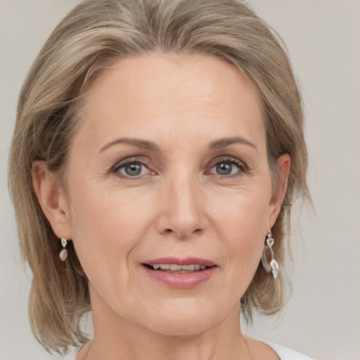 Joyful white adult female with medium  brown hair and grey eyes