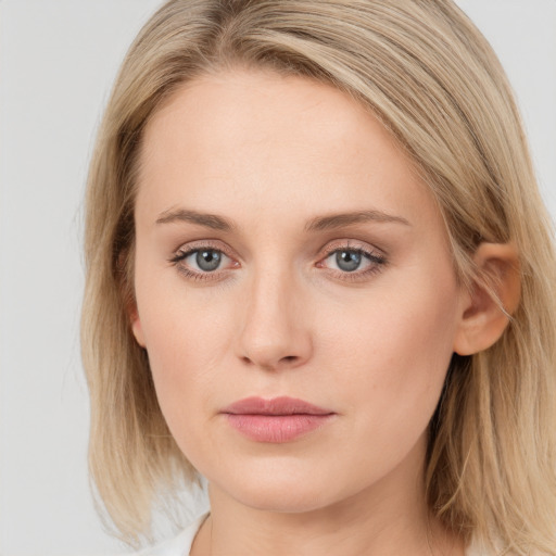 Joyful white young-adult female with long  brown hair and blue eyes