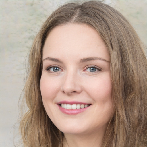 Joyful white young-adult female with long  brown hair and green eyes