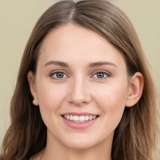 Joyful white young-adult female with long  brown hair and grey eyes