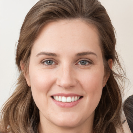 Joyful white young-adult female with long  brown hair and grey eyes