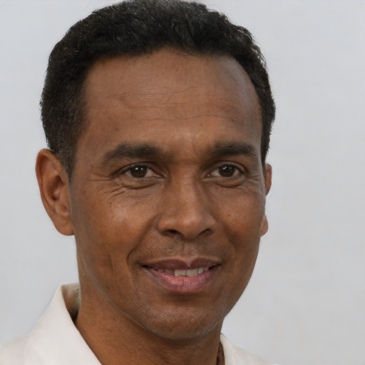 Joyful black adult male with short  brown hair and brown eyes