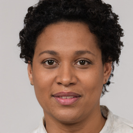 Joyful black adult female with short  brown hair and brown eyes