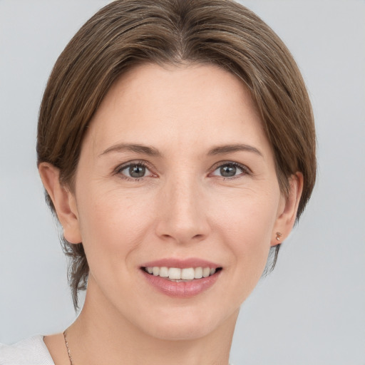 Joyful white young-adult female with medium  brown hair and grey eyes