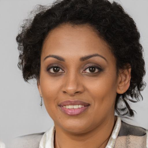 Joyful black young-adult female with medium  brown hair and brown eyes