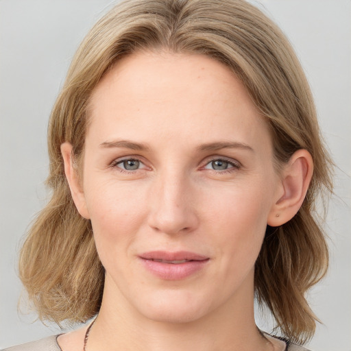 Joyful white young-adult female with medium  brown hair and blue eyes