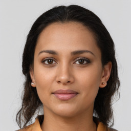 Joyful latino young-adult female with medium  brown hair and brown eyes