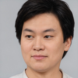 Joyful asian young-adult male with short  brown hair and brown eyes