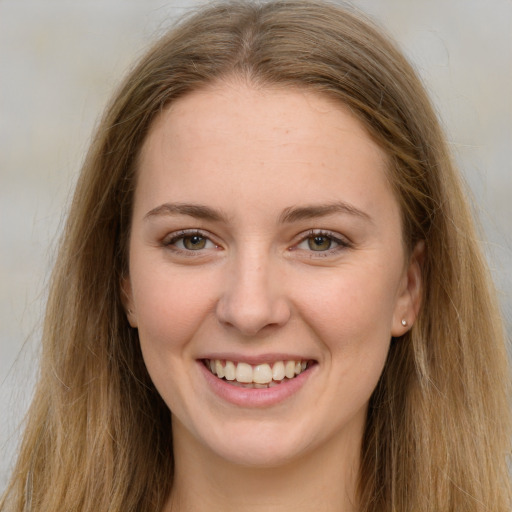 Joyful white young-adult female with long  brown hair and green eyes