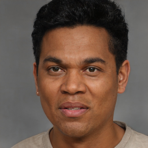 Joyful black adult male with short  black hair and brown eyes