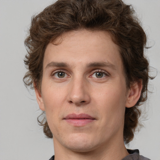 Joyful white young-adult male with medium  brown hair and grey eyes