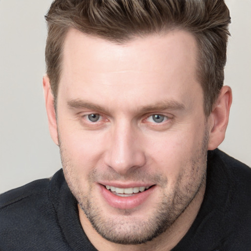 Joyful white adult male with short  brown hair and blue eyes