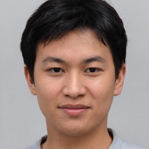 Joyful asian young-adult male with short  brown hair and brown eyes