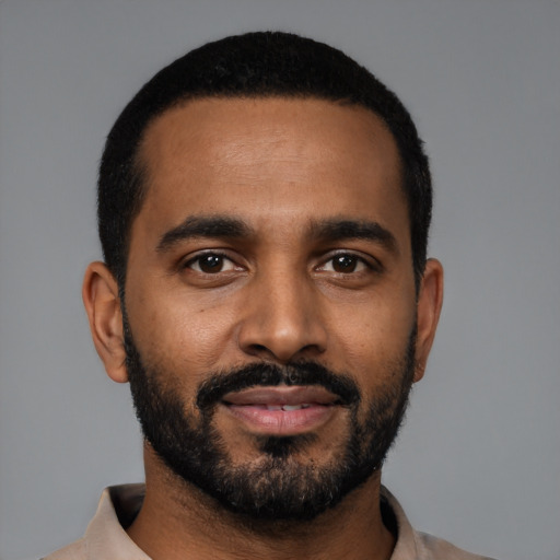 Joyful black young-adult male with short  black hair and brown eyes
