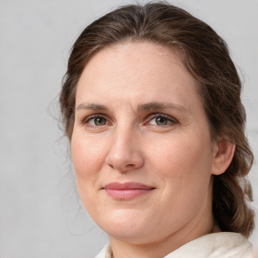 Joyful white adult female with medium  brown hair and grey eyes