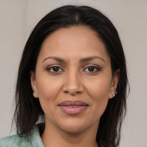 Joyful latino adult female with medium  brown hair and brown eyes