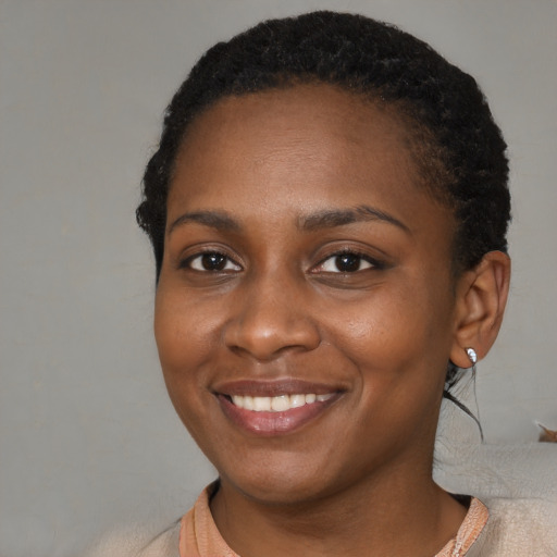 Joyful black young-adult female with medium  brown hair and brown eyes