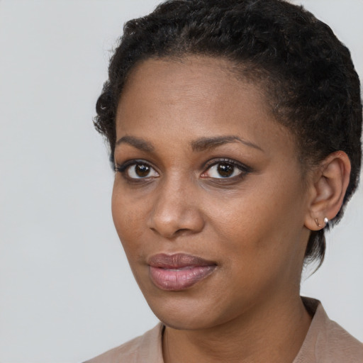 Joyful black young-adult female with short  brown hair and brown eyes