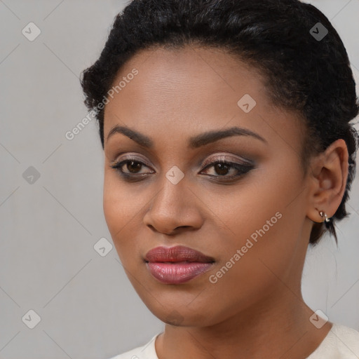 Joyful black young-adult female with short  black hair and brown eyes