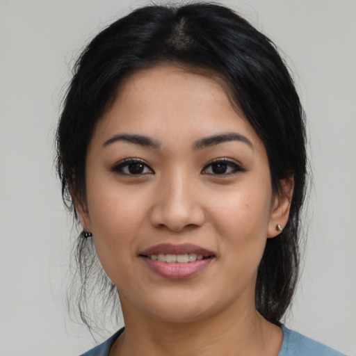 Joyful latino young-adult female with medium  black hair and brown eyes