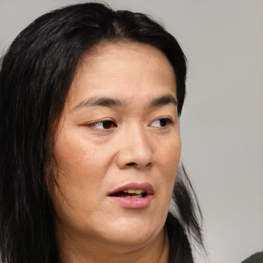 Joyful asian adult female with long  brown hair and brown eyes
