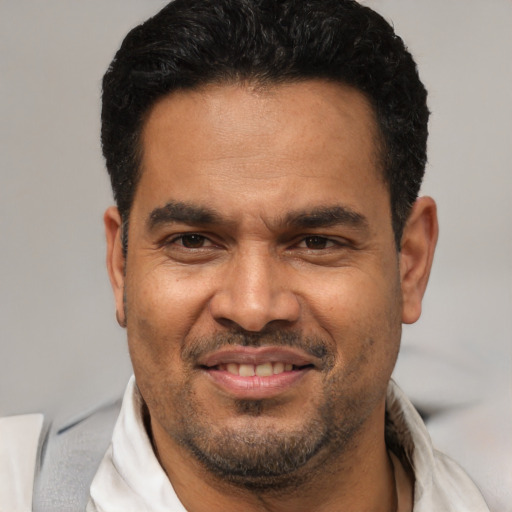 Joyful latino adult male with short  brown hair and brown eyes