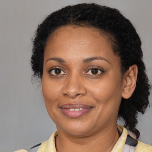 Joyful black young-adult female with short  brown hair and brown eyes