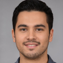 Joyful white young-adult male with short  black hair and brown eyes