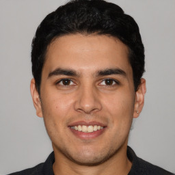 Joyful white young-adult male with short  black hair and brown eyes
