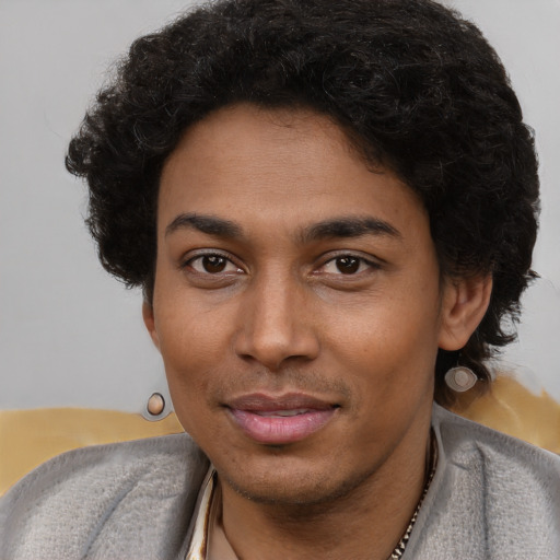 Joyful black young-adult male with short  brown hair and brown eyes