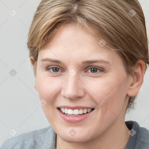 Joyful white young-adult female with medium  brown hair and grey eyes