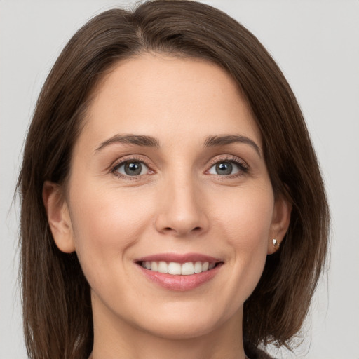 Joyful white young-adult female with long  brown hair and grey eyes